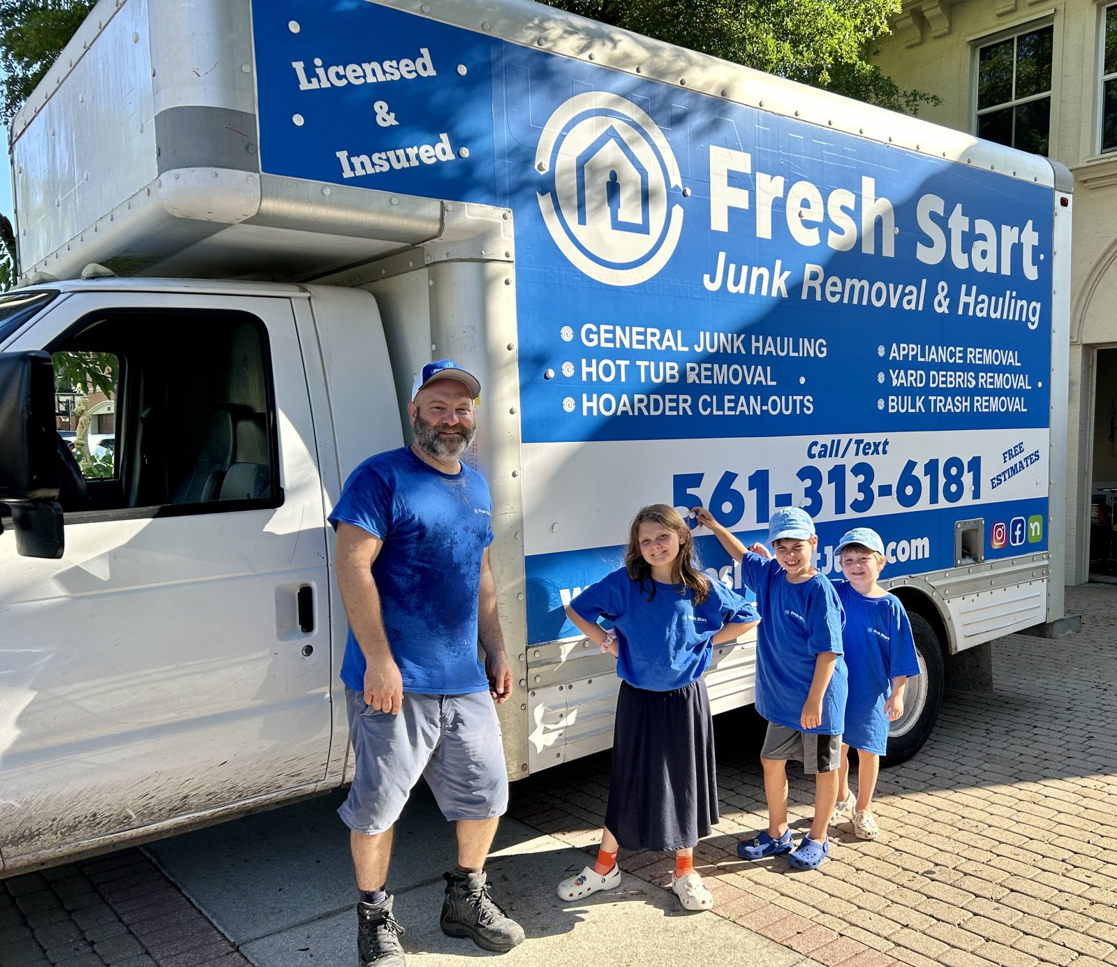 Family-owned Fresh Start Junk Removal & Hauling. Owner and his kids in matching branded shirts in front of the Fresh Start truck in South Florida